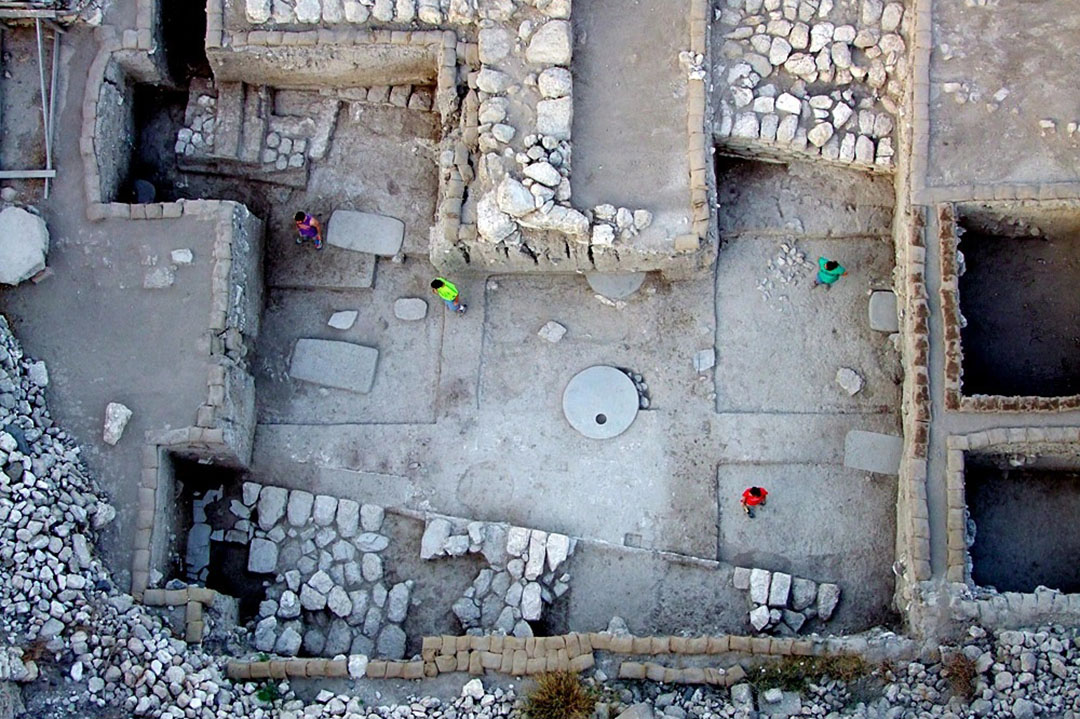 Aerial shot of the foundations of a dig, with stone walls and rooms
